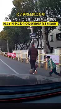 父子俩边走路边打球，孩子球掉了立马冲出去捡差点被撞...